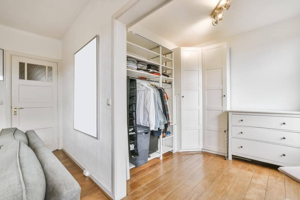Full white custom built in closet in a room with wooden flooring
