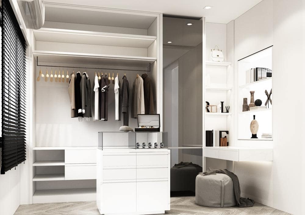 walk in closet with white closets and island with accessories