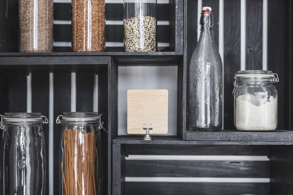 Black pantry shelf with dry grains and jars