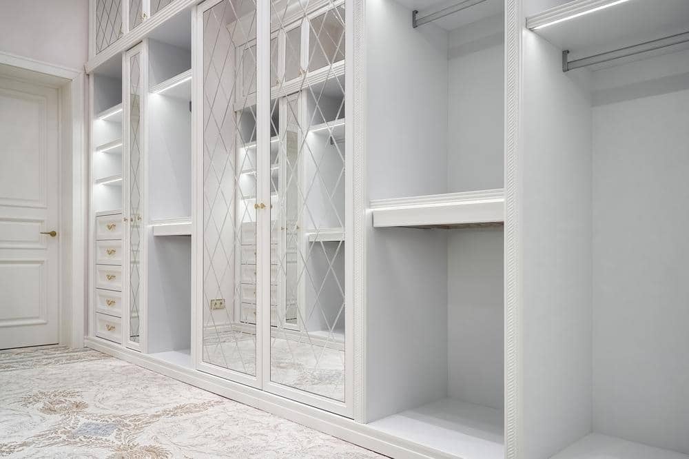 White walk in closet with open empty shelves and hangers