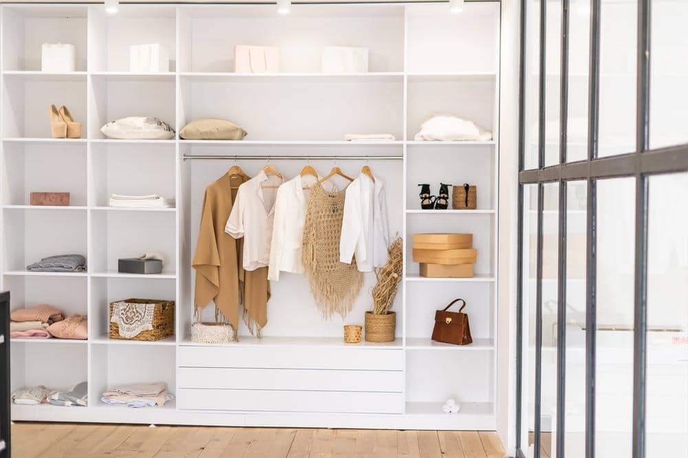 White wardrobe with no doors and white shelves and hanging racks