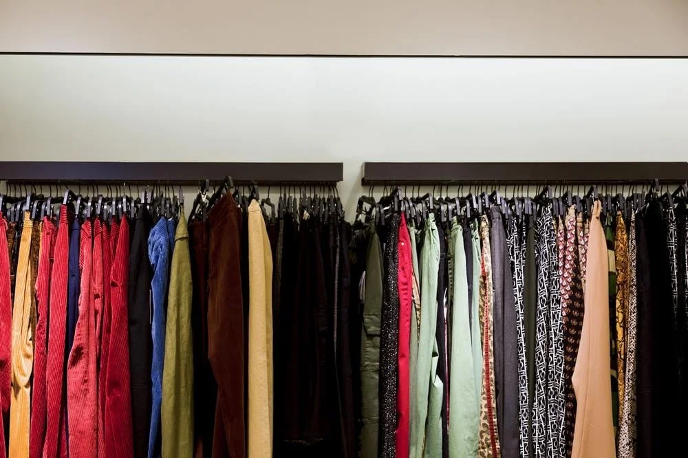 Colorful clothes and skirts hanging on a hanger according to their colors