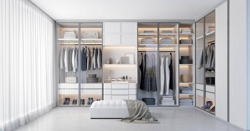 white modern closet with glass doors and a white ottoman