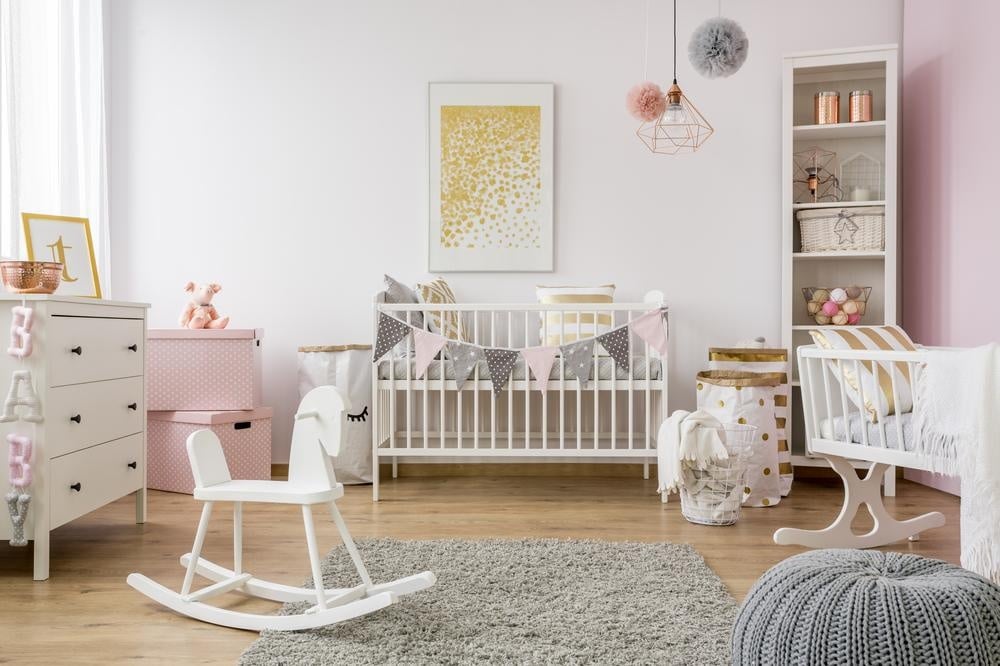 Soft pink baby's room with small bed and toys