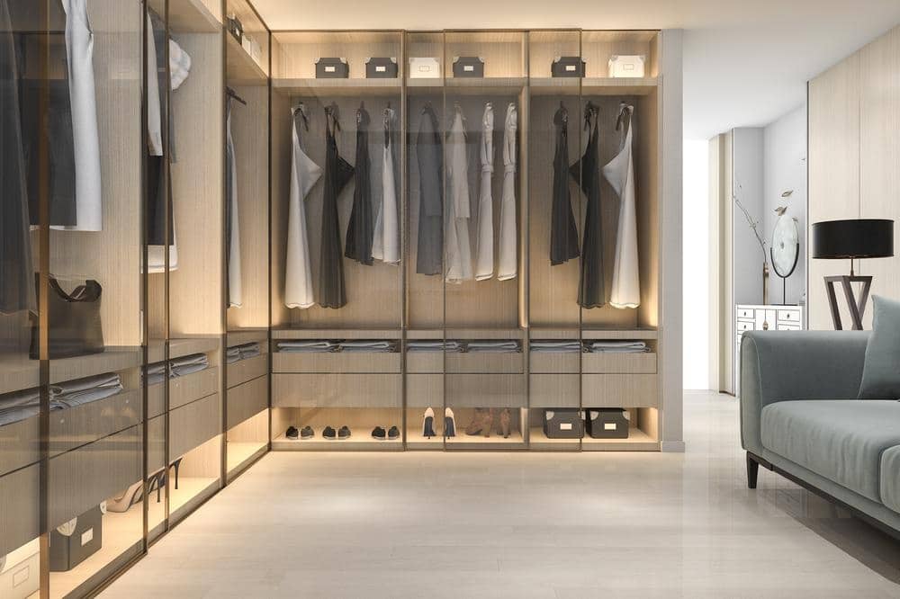 Master closet with glass doors and lighted shelves