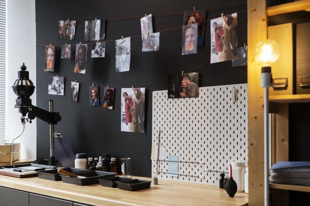 Dark room table with photos hanging on its board