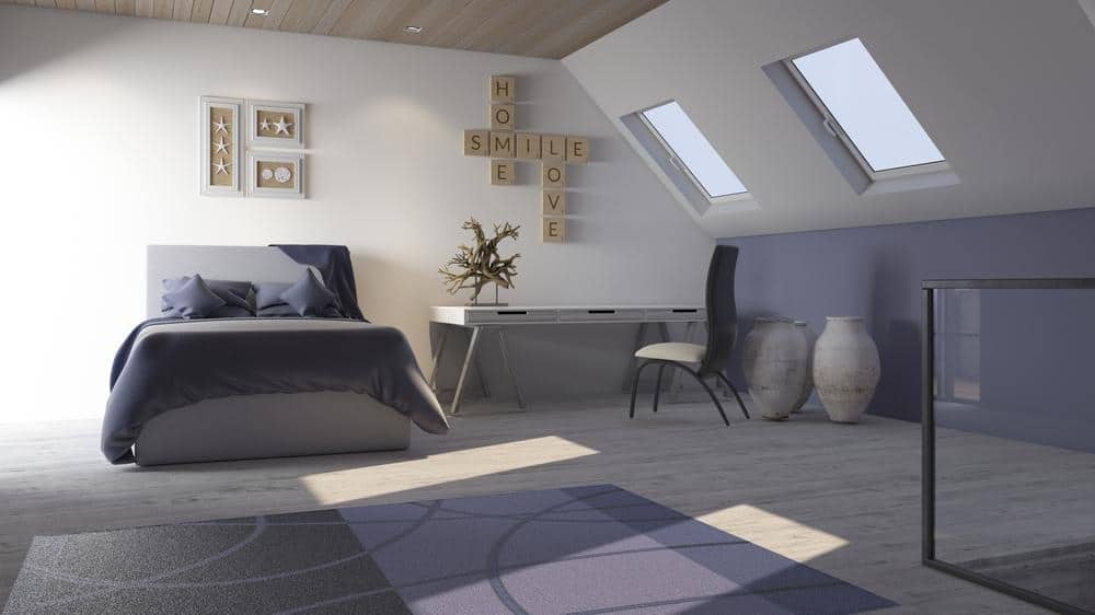 Attic room with small desk and large bed with wall decorations
