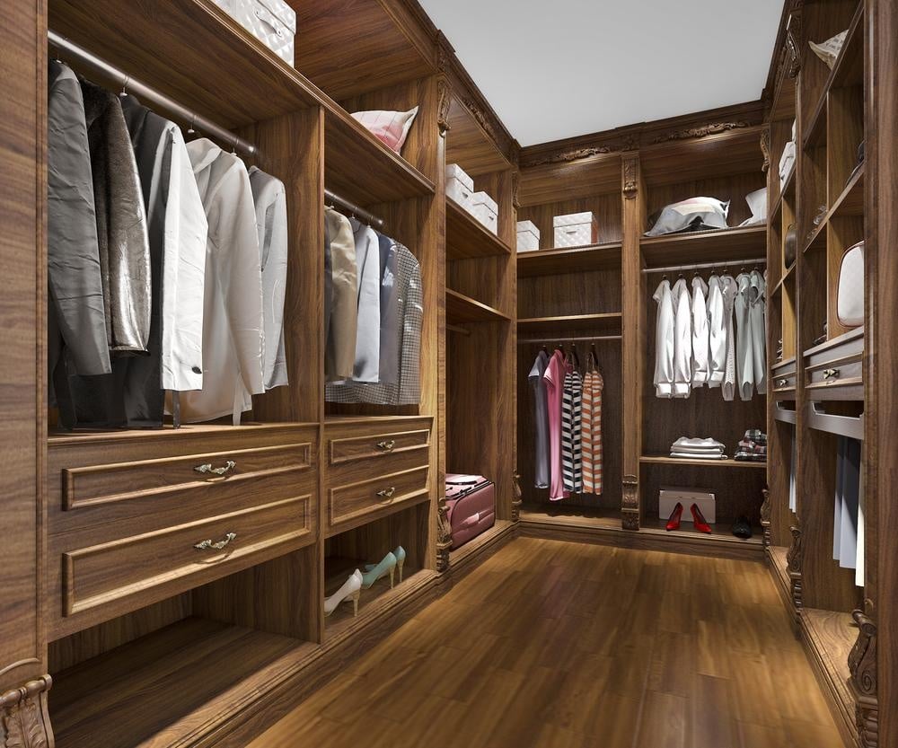 Wooden walk in closet with three walls hanging clothes inside
