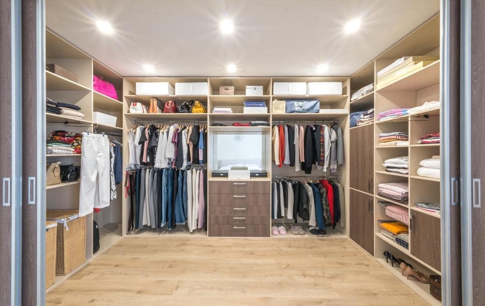 Large walk in closet with spotlights on the ceiling and shelves on the closet