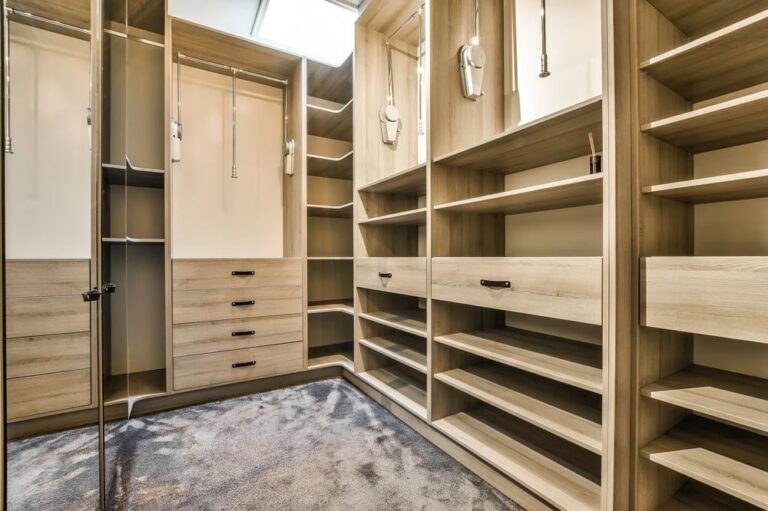 Empty custom walk in closet with drawers and movable hanging rods
