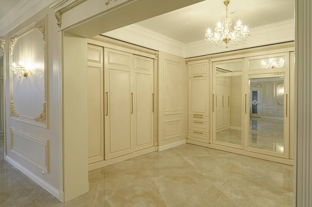 White luxury walk in closet with mirrors on the doors