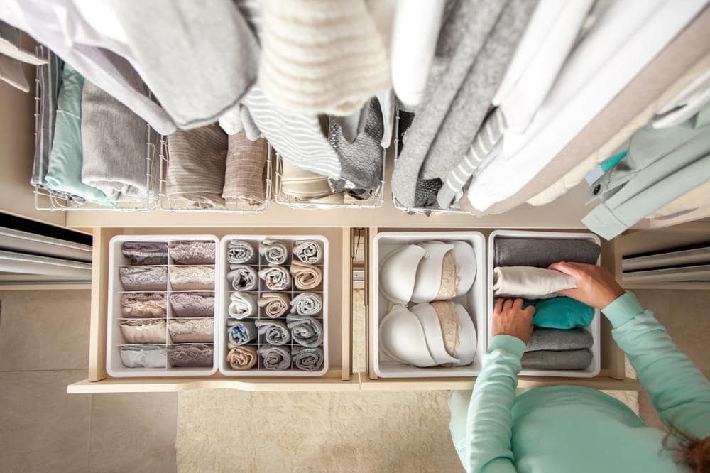 Unidentified neat housewife puts container with socks panties underwear clothes storage | mastering the art of organizing a walk-in closet: a comprehensive guide